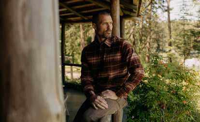 fit model sitting wearing The Ledge Shirt in Chestnut Plaid