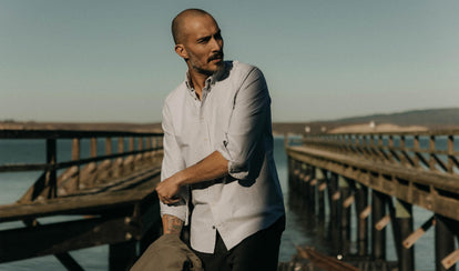 fit model adjusting the sleeves on The Jack Oxford Shirt in Navy University Stripe