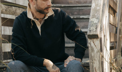 fit model sitting wearing The Rugby Shirt in Coal