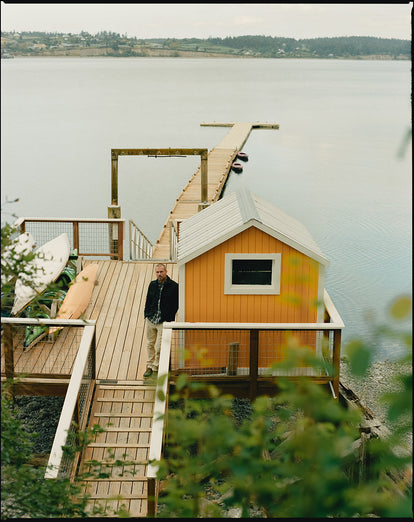 Model standing by a yellow cabin at Captain Whidbey.