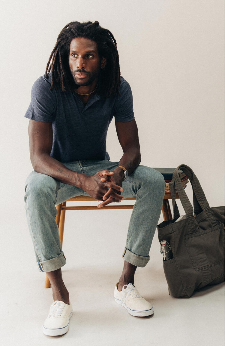 fit model sitting wearing The Merino Polo in Heather Navy