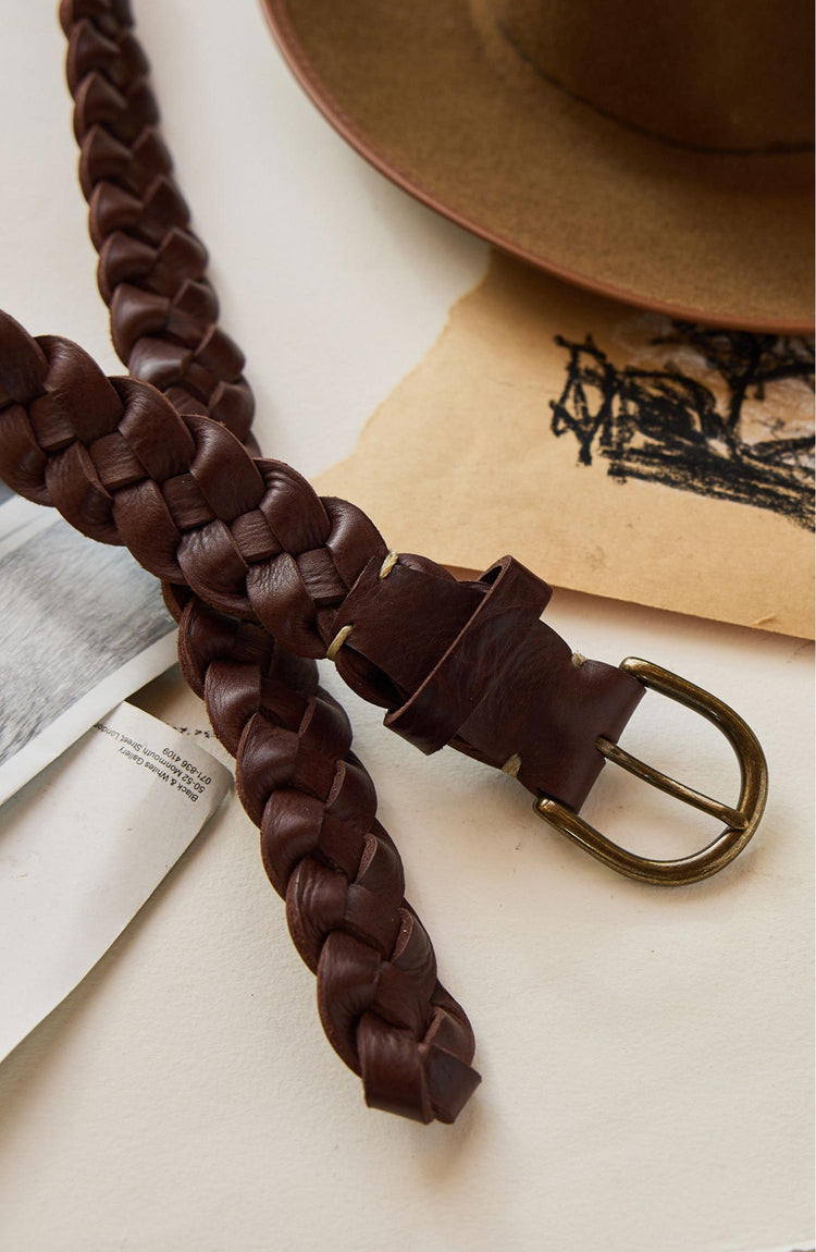 editorial image of The Braided Belt in Dark Brown on a stack of paper