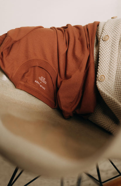 editorial image of The Cotton Hemp Tee in Fired Clay on a chair