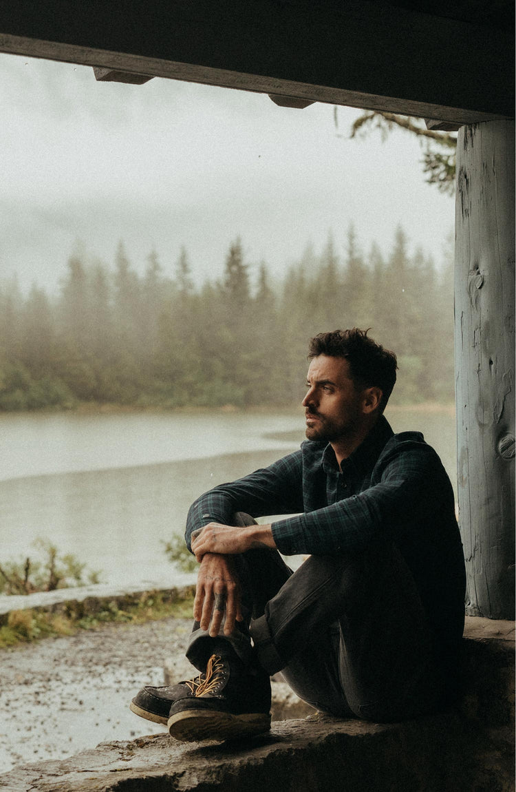 fit model sitting wearing The Jack in Blackwatch Plaid