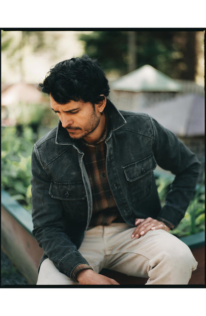 fit model sitting wearing The Shop Shirt in Coal Chipped Canvas