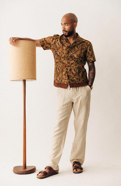 fit model leaning on a lamp wearing The Short Sleeve Davis Shirt in Burnt Toffee Print