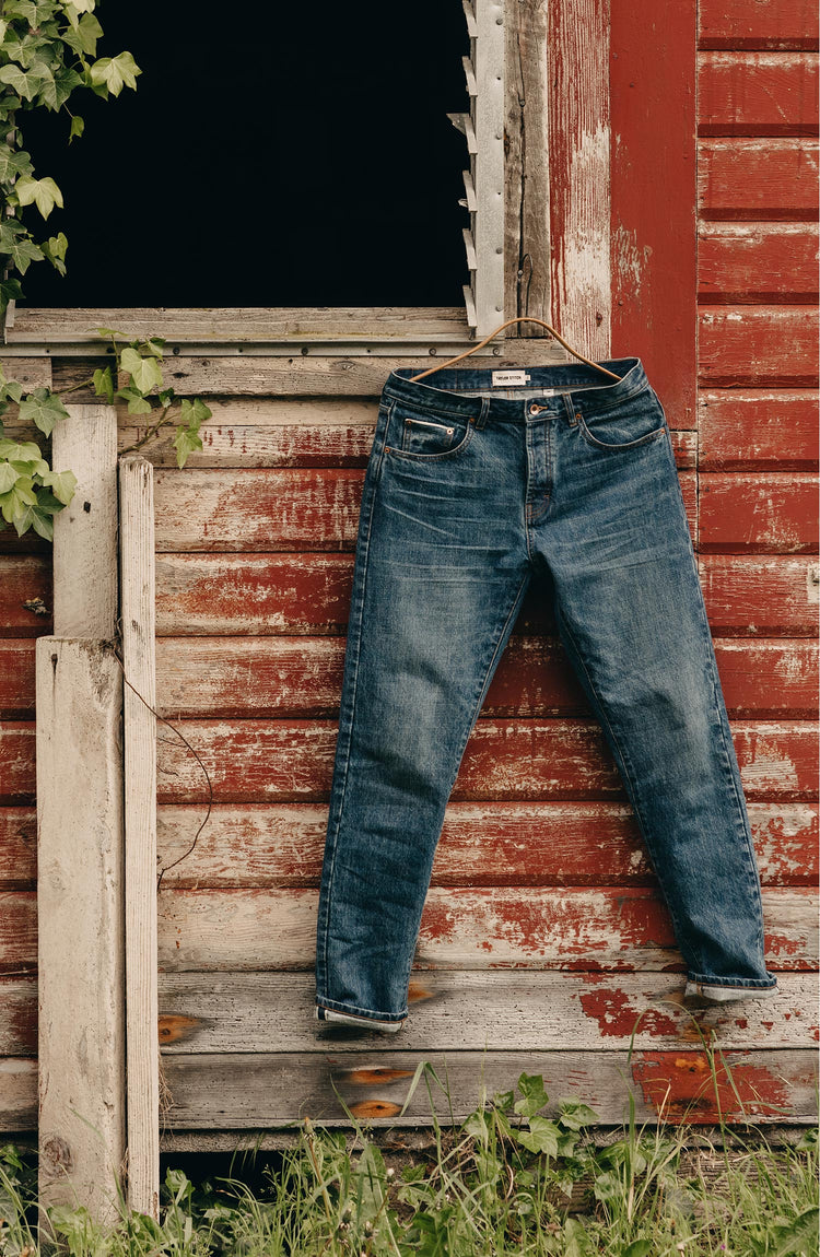 editorial image of The Slim Jean in Mid Wash Organic Selvedge hanging