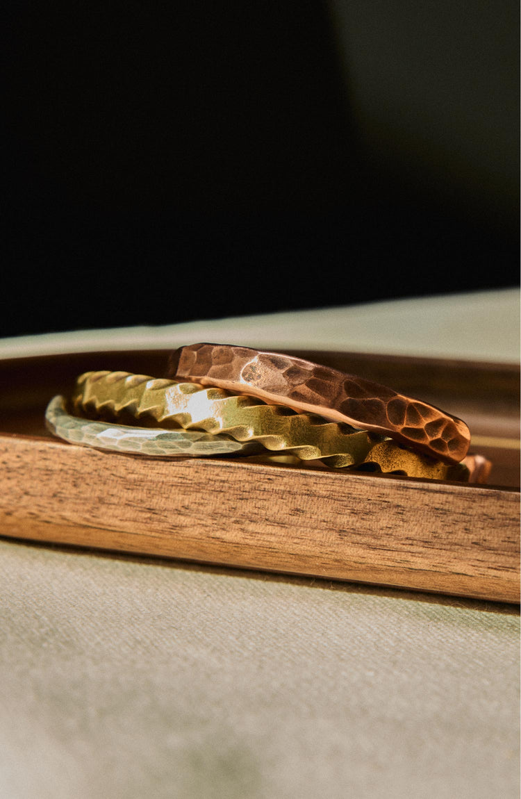 editorial image of The Hammered Cuff in Sterling Silver with various other cuffs