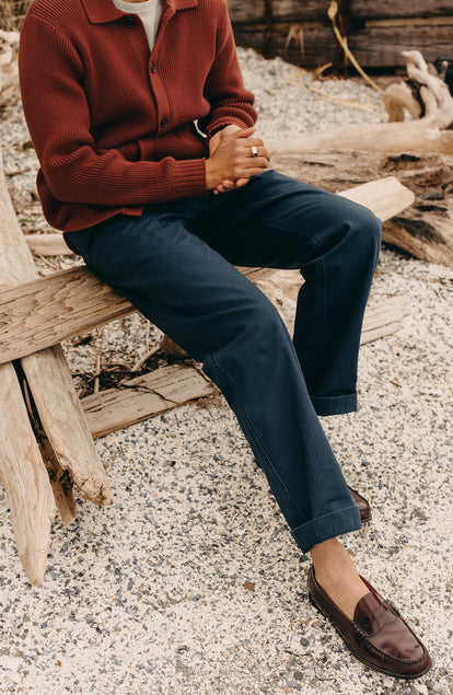 fit model sitting wearing The Matlow Pant in Dark Navy Herringbone