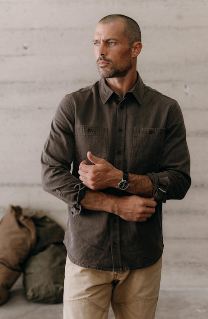 fit model adjusting the cuffs on The Utility Shirt in Soil Selvedge Denim