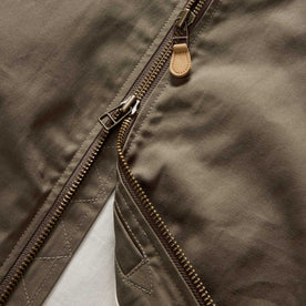 material shot of the zipper on The Bomber Jacket in Fatigue Olive Dry Wax, Outerwear by Taylor Stitch