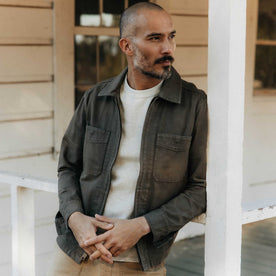 fit model leaning against a pole wearing The Station Jacket in Fatigue Olive Broken Twill, Outerwear by Taylor Stitch