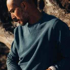 fit model leaning against a tree wearing The Apres Crew in Washed Indigo Terry, Knits by Taylor Stitch