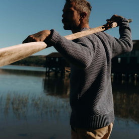 fit model holding an oar wearing The Fisherman Sweater in Blue Melange, Knits by Taylor Stitch