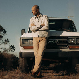 fit model leaning against a car wearing The Shifter Jacket in Stone Pigment Canvas, Outerwear by Taylor Stitch