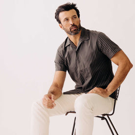 fit model sitting wearing The Short Sleeve Davis Shirt in Kelp Stripe