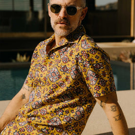 fit model sitting wearing The Short Sleeve Davis Shirt in Tarnished Gold Print