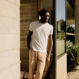 fit model leaning against the wall wearing The Cotton Hemp Tee in Heather Oat, Knits by Taylor Stitch