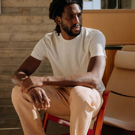 fit model sitting on a chair wearing The Cotton Hemp Tee in Heather Oat, Knits by Taylor Stitch