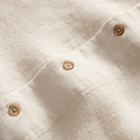 material shot of the buttons on The Short Sleeve Davis Shirt in Natural Palm Embroidery, Wovens by Taylor Stitch