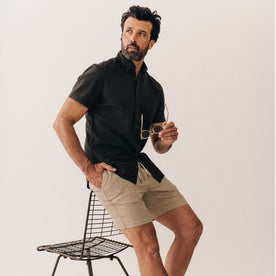 fit model sitting wearing The Short Sleeve Jack in Faded Black Seersucker, Wovens by Taylor Stitch