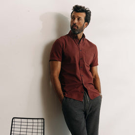 fit model leaning against the wall wearing The Short Sleeve Jack in Dried Cherry Seersucker, Wovens by Taylor Stitch