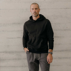 fit model posing in The Apres Hoodie in Black Indigo Terry, Knits by Taylor Stitch