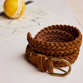 editorial image of The Braided Belt in Tan Suede rolled up next to a ball, Accessories by Taylor Stitch