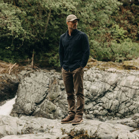 fit model standing on a rock wearing The Jack in Heather Marine Pincord, Wovens by Taylor Stitch