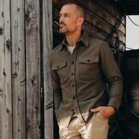 fit model leaning against the wall wearing The Maritime Shirt Jacket in Fatigue Olive Moleskin Twill, Outerwear by Taylor Stitch