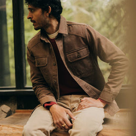 fit model sitting wearing The Shop Shirt in Aged Penny Chipped Canvas, Wovens by Taylor Stitch