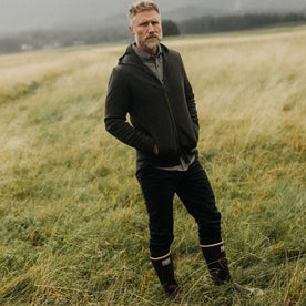 fit model standing in a field wearing The Slim Foundation Pant in Organic Faded Black, Bottoms by Taylor Stitch