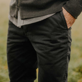 fit model with his hands in his pockets wearing The Slim Foundation Pant in Organic Faded Black, Bottoms by Taylor Stitch