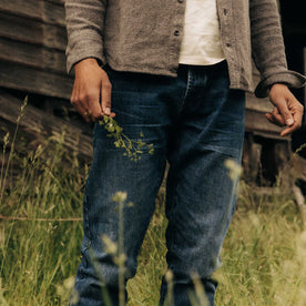 fit model holding plants wearing The Slim Jean in Mid Wash Organic Selvedge, Bottoms by Taylor Stitch