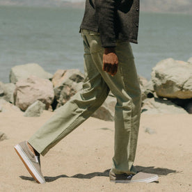 fit model walking on The Surplus Pant in Field Olive Reverse Sateen, Bottoms by Taylor Stitch