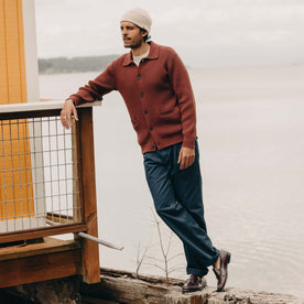 fit model leaning against the wall wearing The Harbor Sweater Jacket in Mahogany, Knits by Taylor Stitch