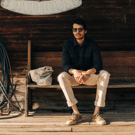 fit model sitting on a bench in The Ledge Shirt in Dark Navy Linen Tweed, Wovens by Taylor Stitch