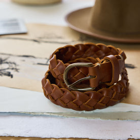 editorial image of The Braided Belt in Whiskey rolled on paper, Accessories by Taylor Stitch