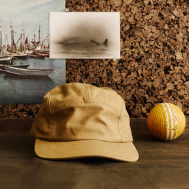 editorial image of The 5-Panel Cap in Khaki Reverse Sateen next to a ball, Accessories by Taylor Stitch