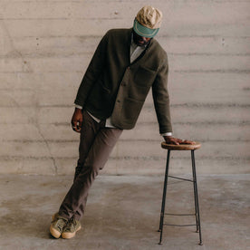 fit model leaning against a stool wearing The Evans Blazer in Forest Birdseye Wool, Outerwear by Taylor Stitch