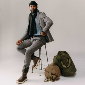 fit model sitting wearing The Textured Knit Scarf in Heather Coal Merino, Accessories by Taylor Stitch