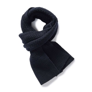 editorial image of The Textured Knit Scarf in Heather Navy Merino rolled up, Accessories by Taylor Stitch