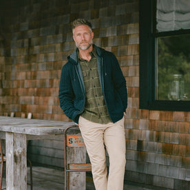 fit model leaning against the wall wearing The Ledge Shirt in Olive Plaid, Wovens by Taylor Stitch