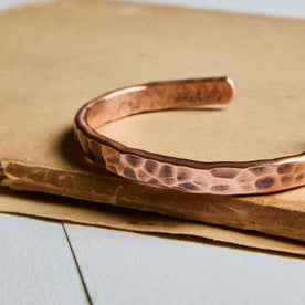 editorial image of The Hammered Cuff in Copper on a piece of paper, Accessories by Taylor Stitch