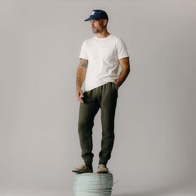 fit model standing on rope wearing The Quilted Apres Pant in Heather Fatigue Olive Jersey, Bottoms by Taylor Stitch