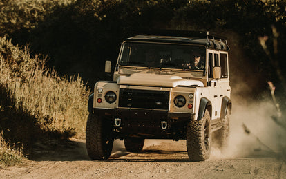 A Landrover beind driven down a dirt road, towards the camera.