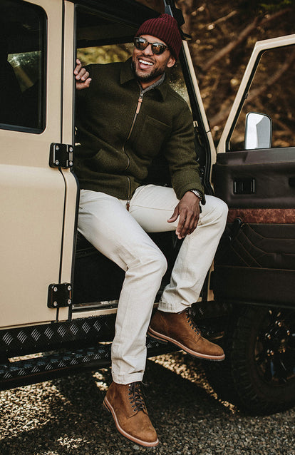 Close up on pants and boots, climbing out of the passenger door.