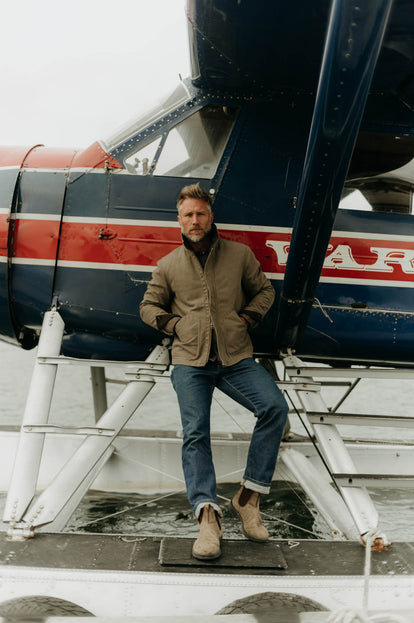 Model standing in front of a seaplane in The Workhorse Jacket