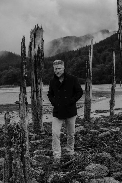 Model wearing The Mariner Coat in Dark Navy by the coast in Alaska