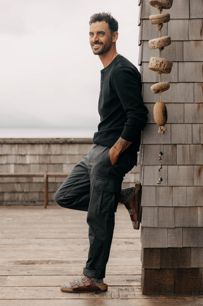 Model leaning against a wall in The Organic Cotton Henley and Tommie Pant